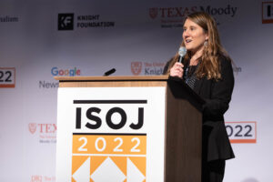 woman talking by podium with ISOJ 2022 lettering