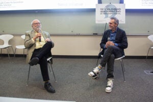 two men talking at a panel