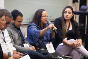 woman with microphone speaking in panel