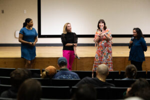 Four women standing in front of audience